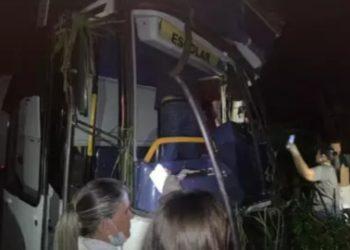 Ônibus com alunos bate em carreta e motorista fica preso às ferragens