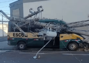 Carro atinge van escolar com 16 crianças e poste de energia cai em cima de utilitário